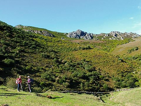 Caminantes en la Sierra de la Manteca, con el Pico L’Urru detrás.