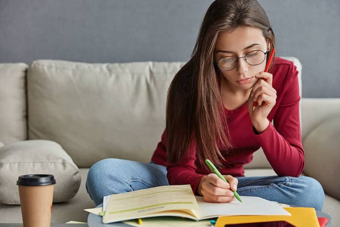 Chica joven escribiendo su curriculum vitae