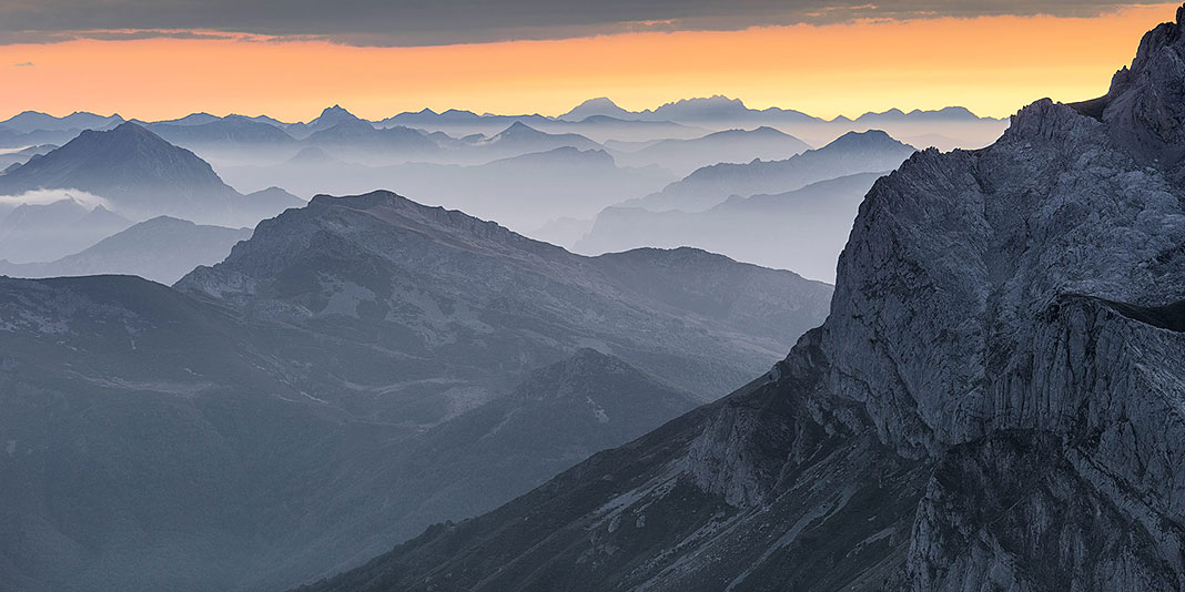 La Cordillera Cantábrica, vista desde los Picos de Europa, se muestra como una interminable sucesión de valles y cordales, como un verdadero mar sólido de montañas. Al fondo, aparece perfectamente identificable la silueta de las cumbres del Macizo de las Ubiñas.
