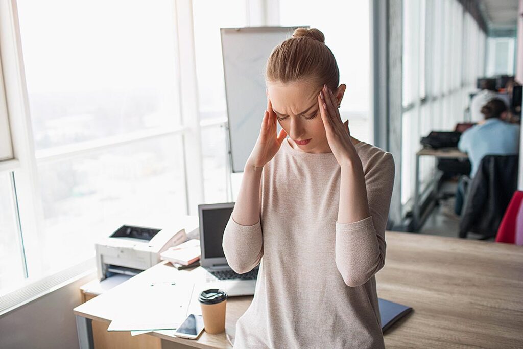 Mujer en el trabajo con migrañas