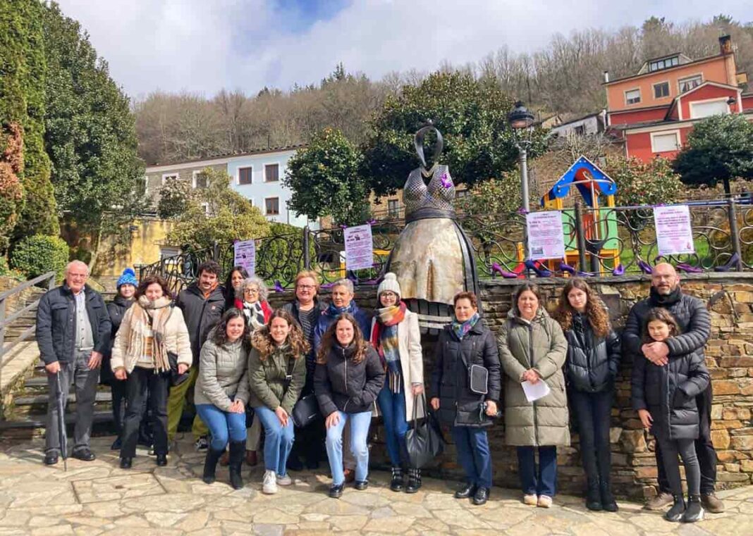 Vecinas y vecinos el pasado 8M junto a la escultura de La Servanda, en Santa Eulalia de Oscos.