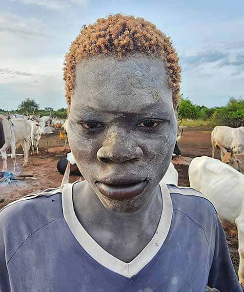 Imagen de un hombre de la tribu mundari con el pelo rubio a razón de la orina caliente de sus reses y cubierto de ceniza.