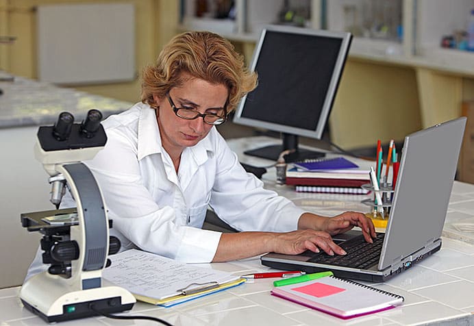 Científica en su lugar de trabajo estudiando.