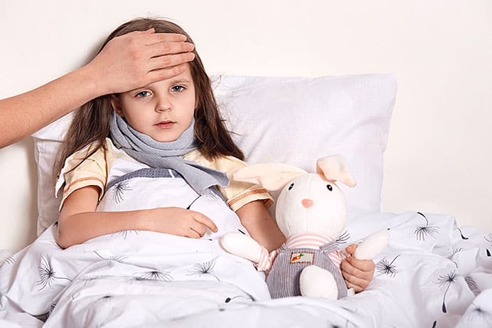 Niña con fiebre en la cama