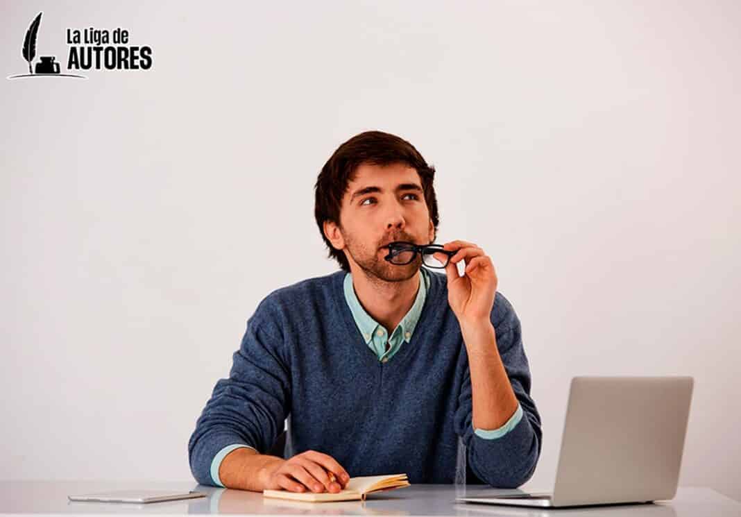 Escritor medita lo que va a escribir en su cuaderno de notas.