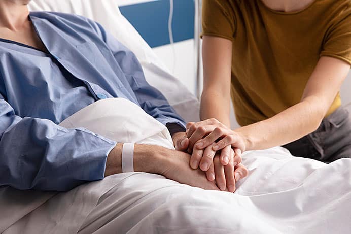 Herminio González Suárez, paliativista. El médico que habla de la muerte para enseñar a vivir 1 Mujer acompaña a su marido en el hospital.