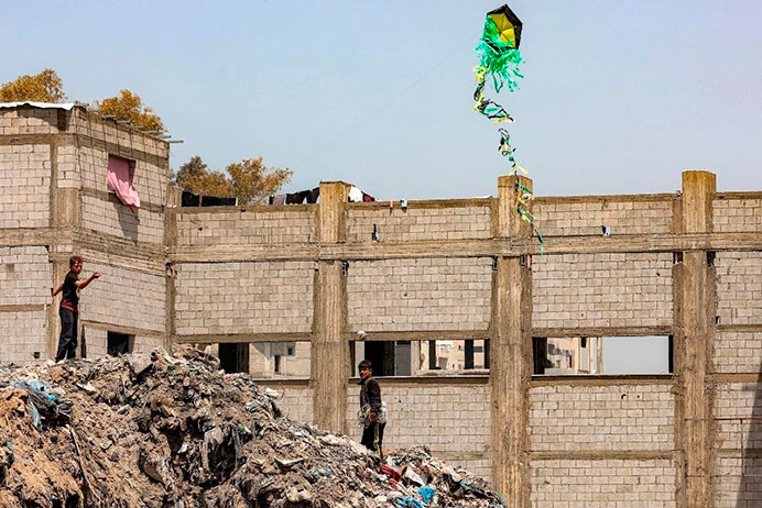 Fraternidad en medio del fuego 1 Niños gazatíes juegan con su cometa sobre los escombros de una Gaza destruida por la guerra.