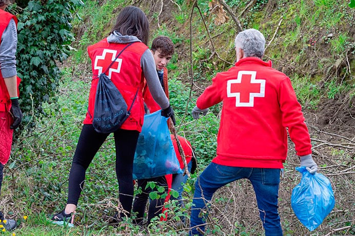 Compromiso, el motor de Cruz Roja en su acción humanitaria 1 Operarios de Cruz Roja en una acción medioambiental.