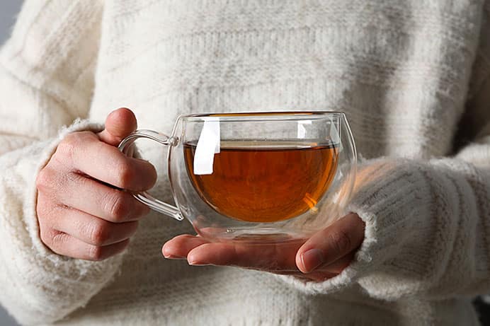 Un estudio relaciona el consumo de café y té con un envejecimiento cerebral más lento 5 Mujer con taza de té en las manos